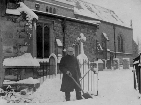 Man shoveling snow in front of church